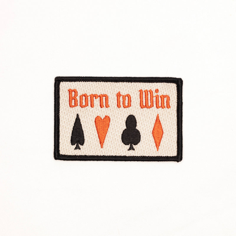 Patch with 'Born to Win' text and card suit symbols on a white background