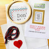 Cross stitch kit with hoop, thread, and printed pattern on a wooden surface