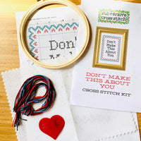 Cross stitch kit with hoop, thread, and printed pattern on a wooden surface