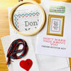 Cross stitch kit with hoop, thread, and printed pattern on a wooden surface