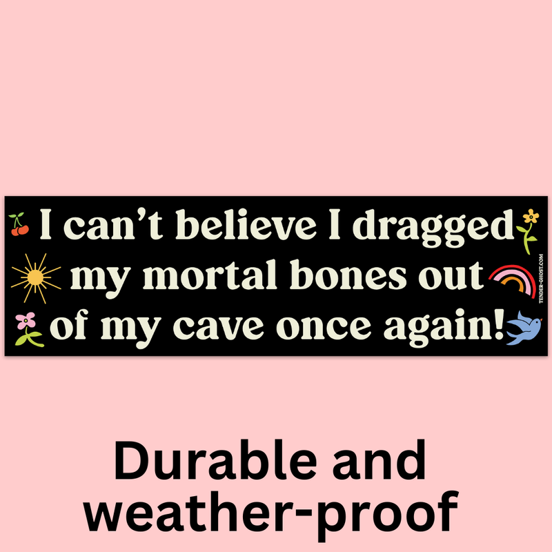 Text bumper sticker with humorous quote of "I can't believe I dragged my mortal bones out of my cave once again" on a pink background