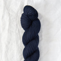 Navy blue skein of yarn on a white background