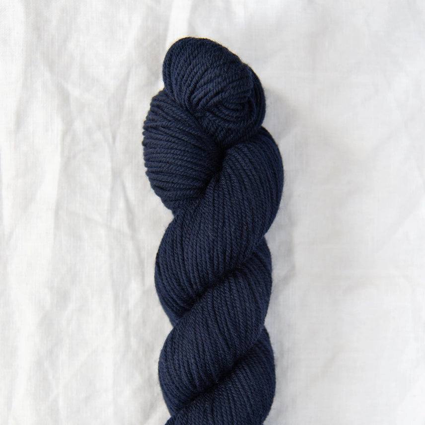 Navy blue skein of yarn on a white background