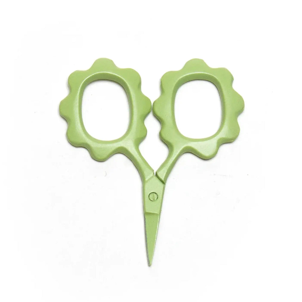 Green scissors with floral handles on a white background