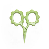 Green scissors with floral handles on a white background