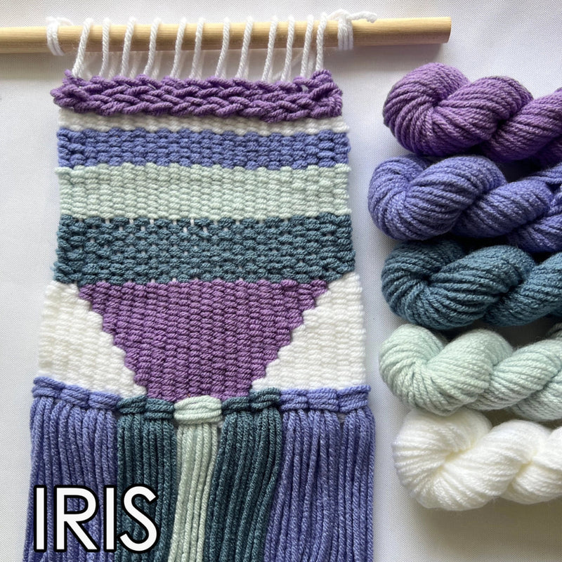 Woven wall art with colorful yarn and skeins on a white background, featuring the brand 'IRIS'.