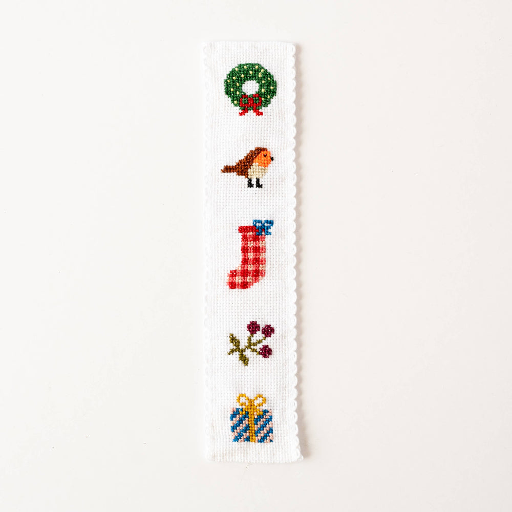 Cross-stitched design with Christmas-themed elements on a white background