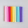Various shades of felt sheet rolls in pinks, oranges, yellows, blues, and purples on a textured white background