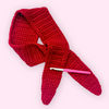 Red crocheted scarf with a pink crochet hook on a white background