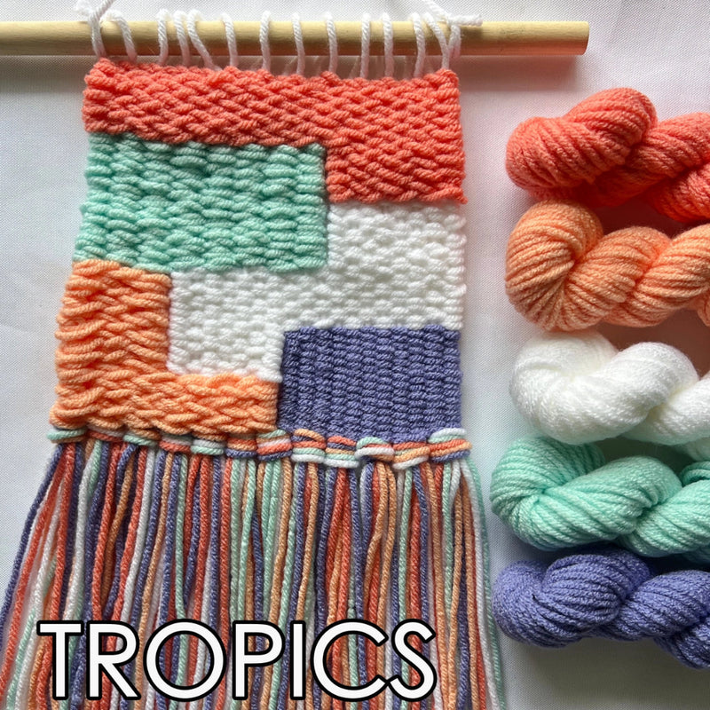 Woven wall art with colorful yarn and 'Tropics' text