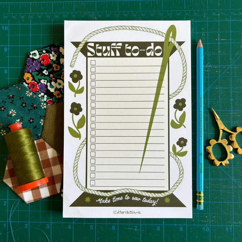 Notepad with 'Stuff to do' list on a green cutting mat with sewing supplies.