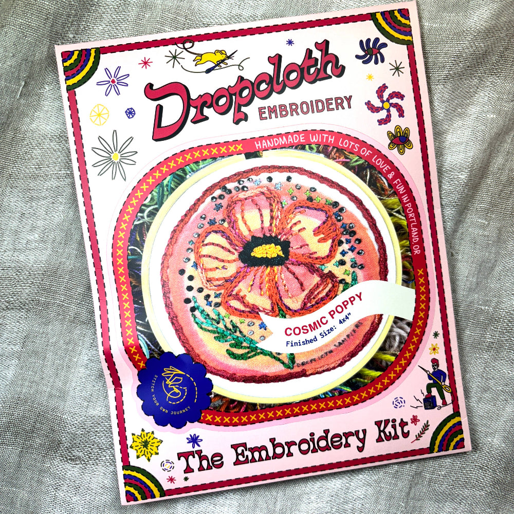 Embroidery kit packaging with 'Dropoloth Embroidery' branding on a textured fabric background.