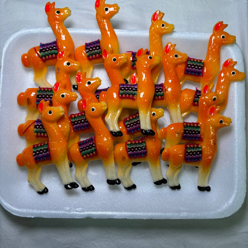 white tray of orange llama magnets, each llama had a woven blanket on its back.