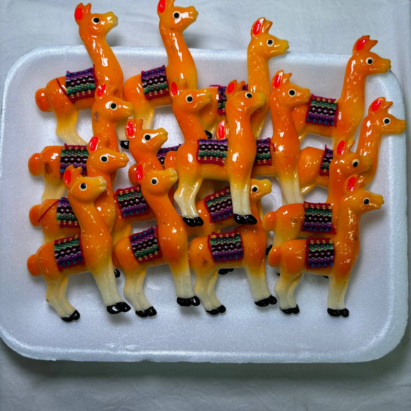 white tray of orange llama magnets, each llama had a woven blanket on its back.