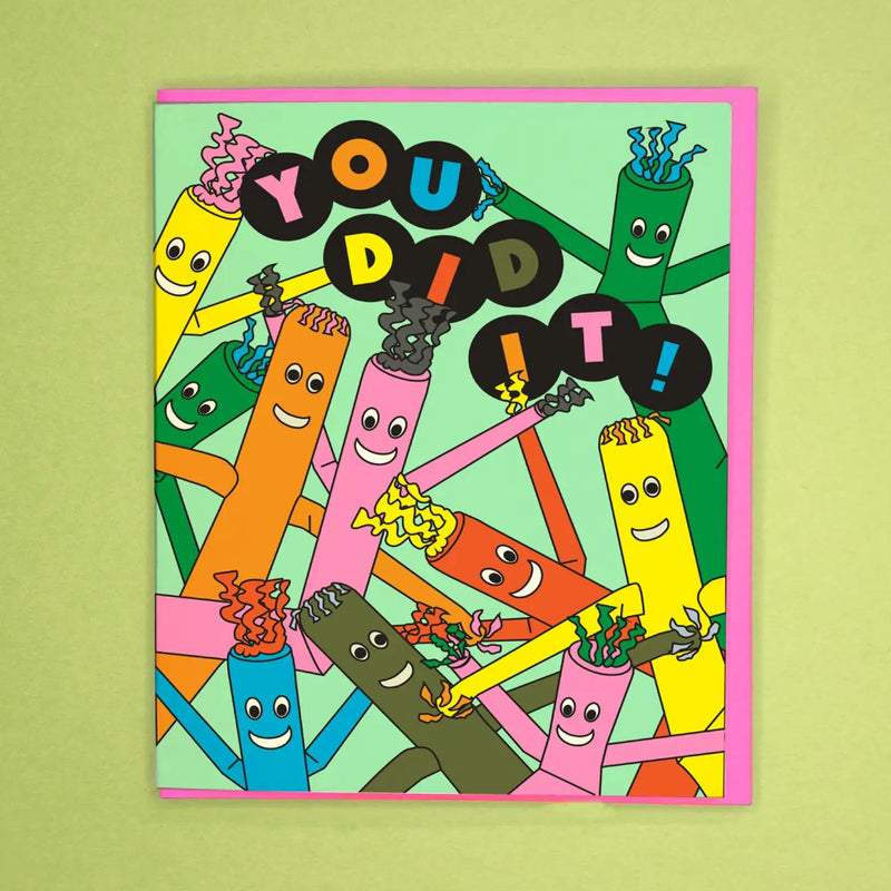Colorful card with inflatable tube men holding up text 'YOU DID IT!' on a green background