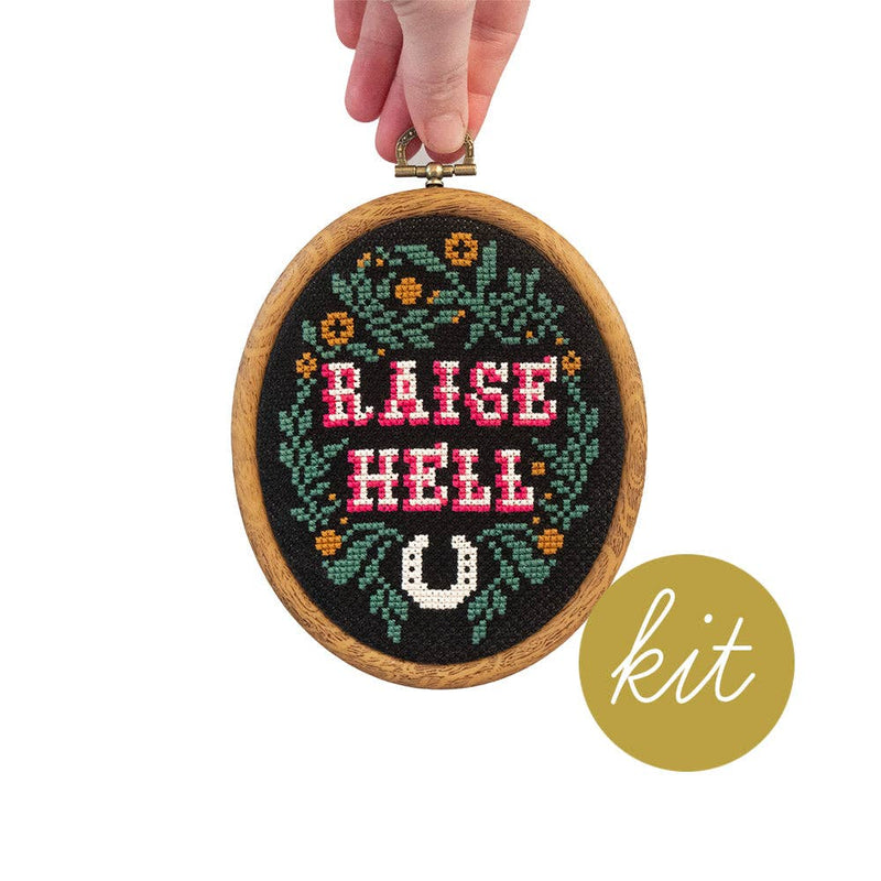 Embroidery hoop with 'Raise Hell U' text and a hand holding it, with 'kit' label on a white background