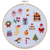 Cross-stitched Christmas-themed design in an embroidery hoop on a light blue background