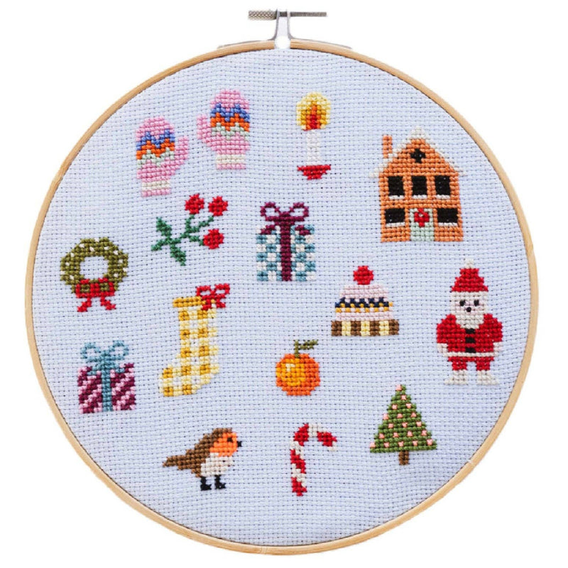 Cross-stitched Christmas-themed design in an embroidery hoop on a light blue background