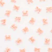 Pattern of small pink bows on a white background