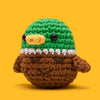 Crocheted bird toy with green head, brown body, and yellow beak on a yellow background