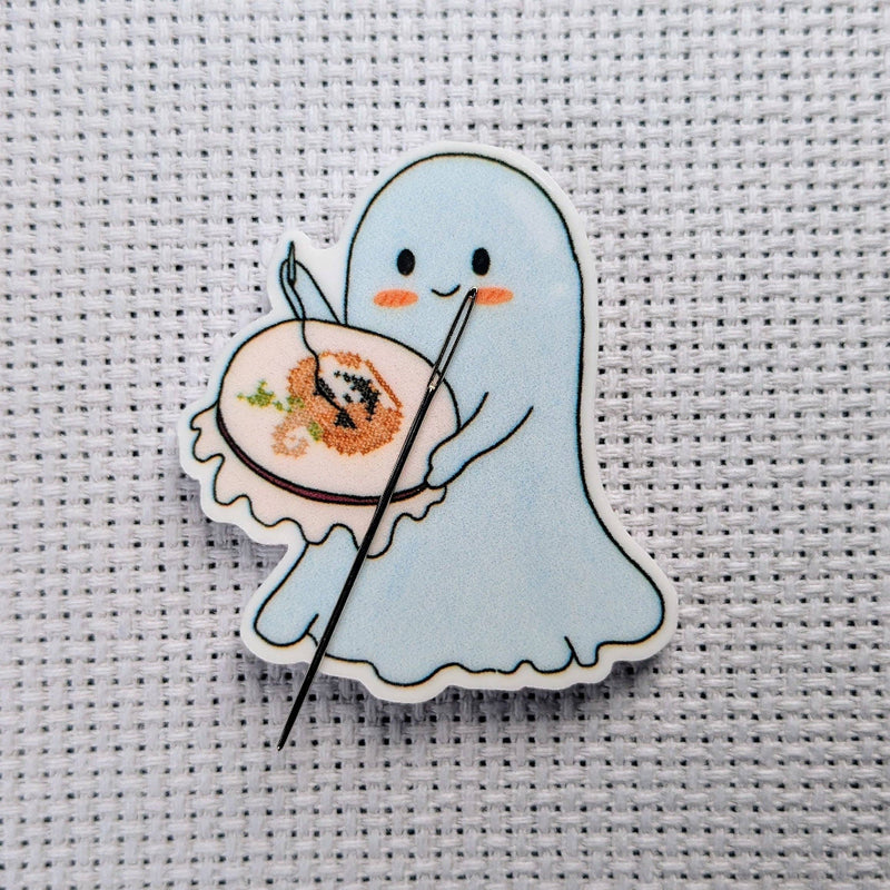 Cartoon ghost holding a cross-stitched piece on a textured background