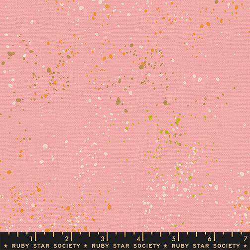 Pink fabric with gold and white speckles and a ruler at the bottom.