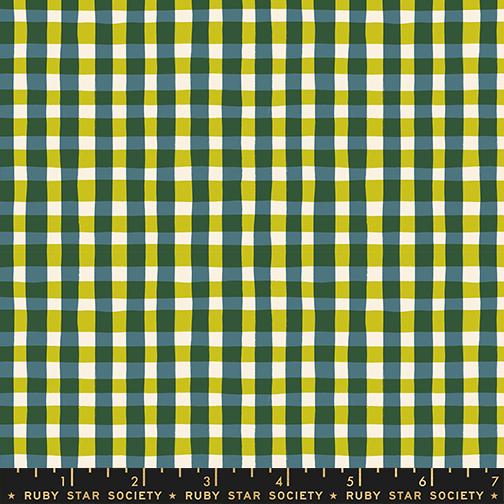 Plaid fabric with green, yellow, and white pattern, featuring a ruler at the bottom.