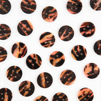Pattern of tortoiseshell buttons on a white background
