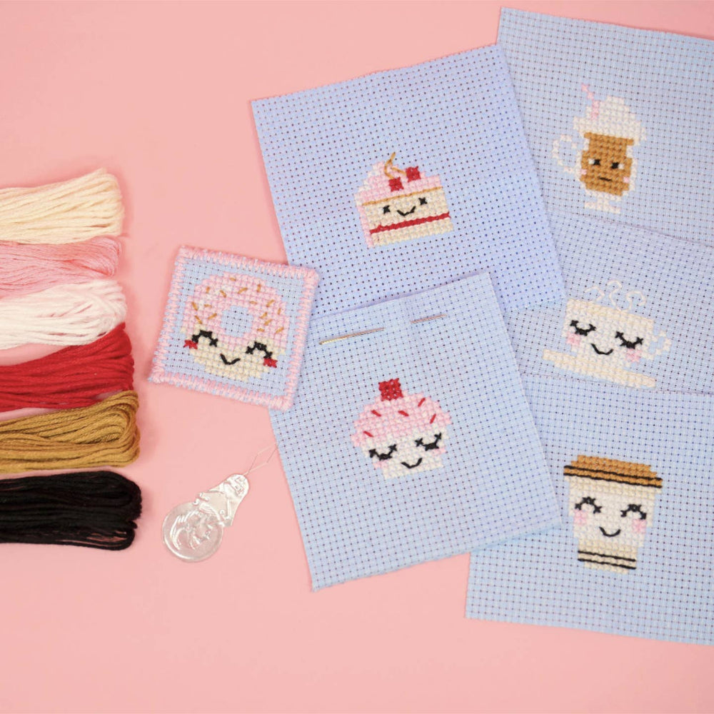 Cross-stitched fabric with cute food designs on a pink background