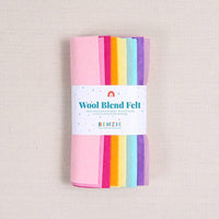 Multicolor shades of felt in pinks, oranges, yellows, blues, and purples with a "Wool Blend Felt" label around them on a textured white background