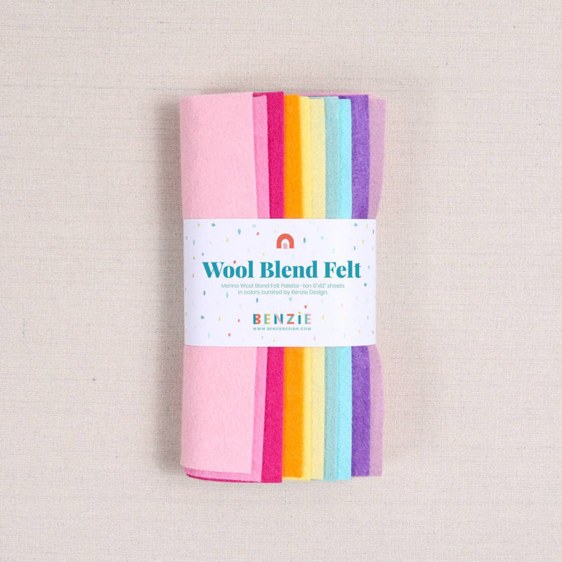 Multicolor shades of felt in pinks, oranges, yellows, blues, and purples with a "Wool Blend Felt" label around them on a textured white background