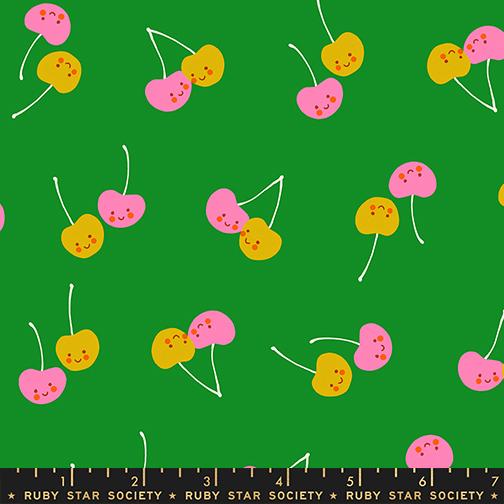 Pattern of colorful cherries on a green background with a ruler at the bottom.