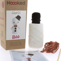 Hoooked DIY craft set for making a ghost amigurumi with yarn, packaging, and pattern sheet on a white background.