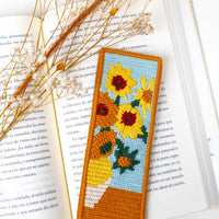 Needlepoint bookmark with sunflower design on an open book