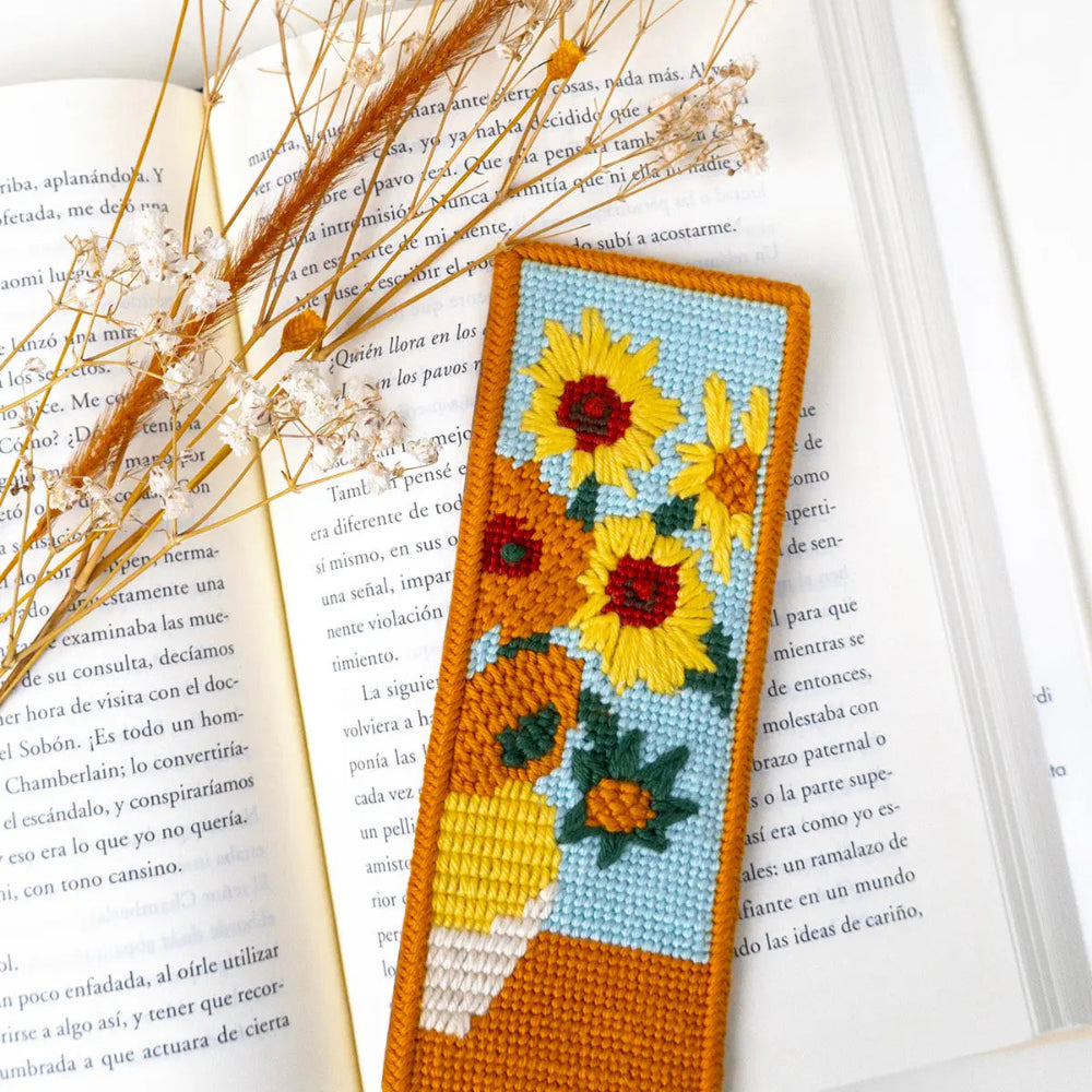 Needlepoint bookmark with sunflower design on an open book
