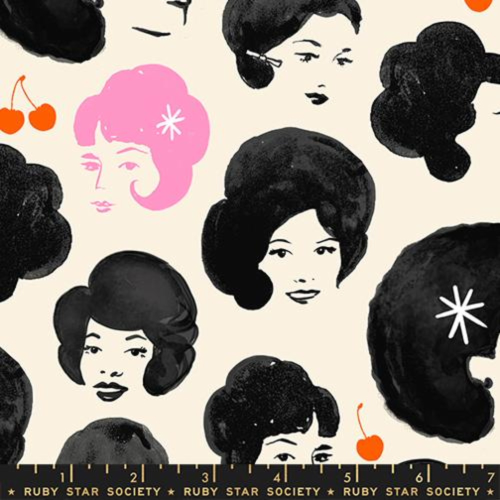 Fabric swatch of black and white drawings of women's faces, an outlying woman drawn in pink is in the upper left. There are red cherries scattered between the women.