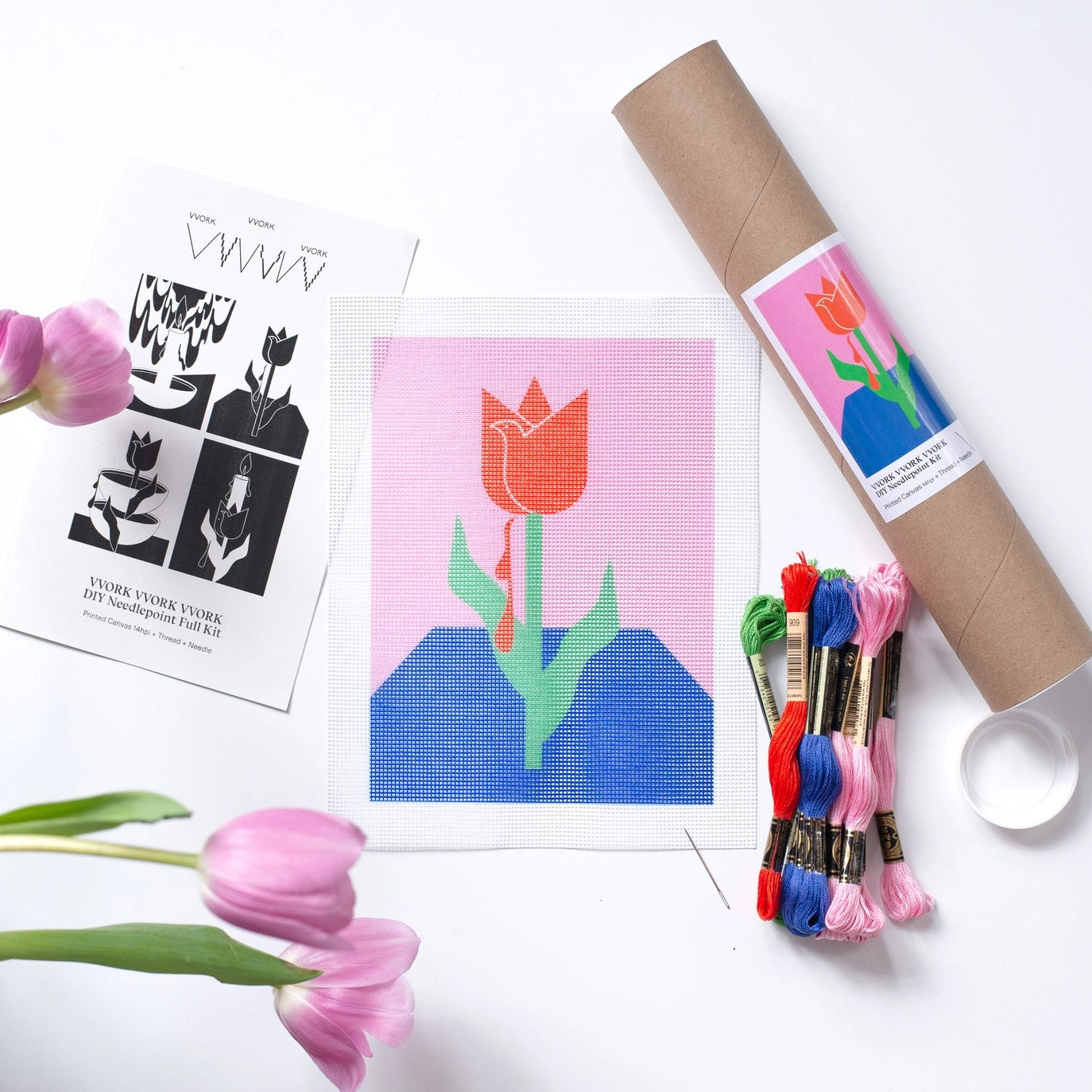 needlepoint kit with red tulip on pink and blue background and embroidery floss 