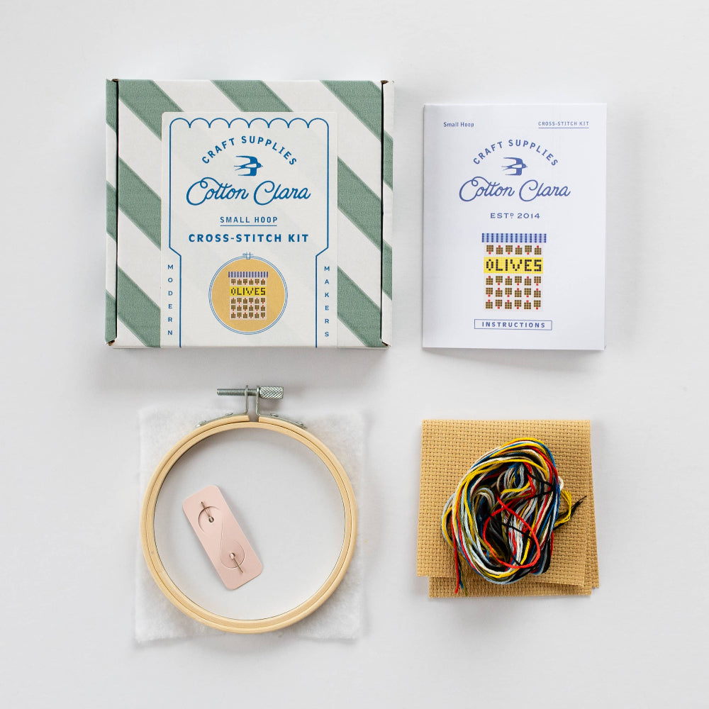 Cotton Clara cross-stitch kit with hoop, floss, and instructions on a white background