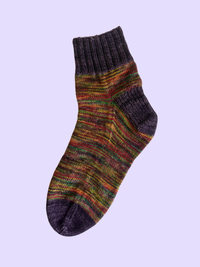 A colorful knit sock on a lavender background.