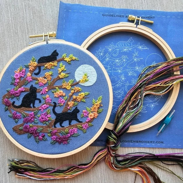 Embroidery kit with three black cats, a full moon, and a beautiful flowering tree