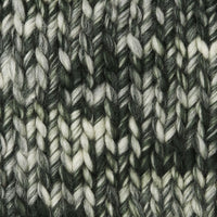 Close-up of a textured knit fabric with a variegated pattern of dark green, charcoal gray, and off-white yarns.