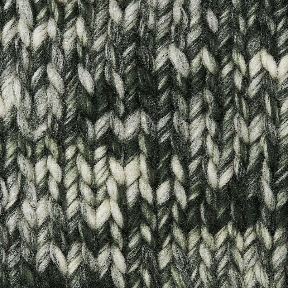 Close-up of a textured knit fabric with a variegated pattern of dark green, charcoal gray, and off-white yarns.