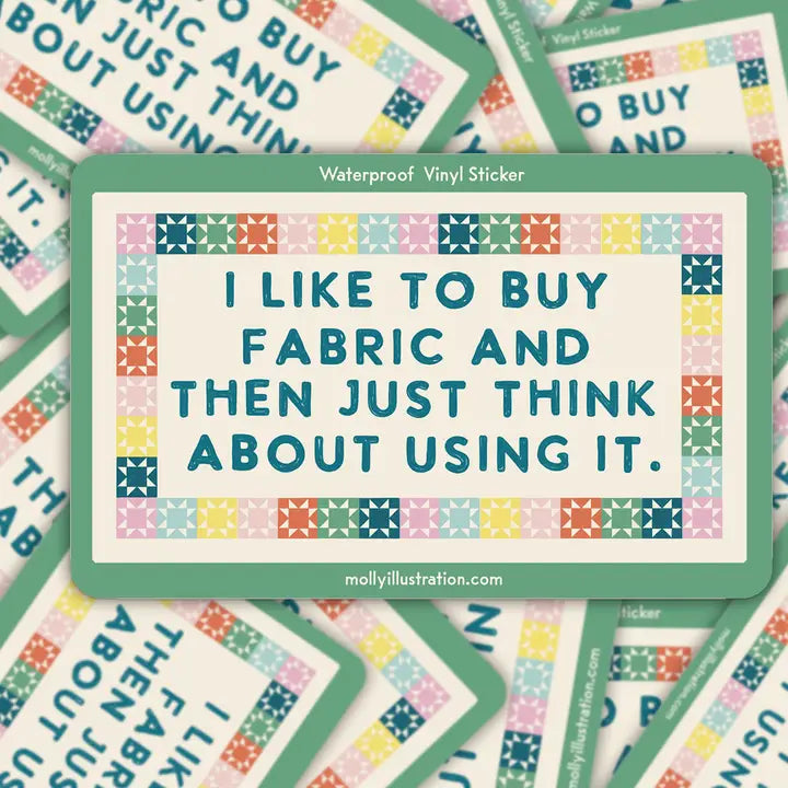 Vinyl sticker with text 'I like to buy fabric and then just think about using it.' on a colorful patterned background.