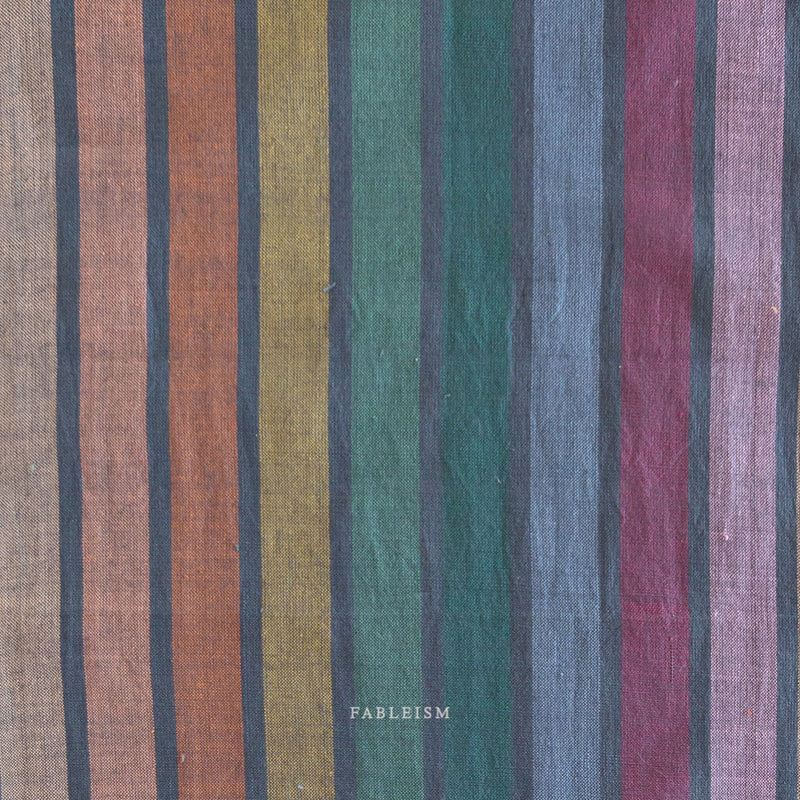 Striped fabric with multicolor pattern on a dark background and 'Fableism' branding.