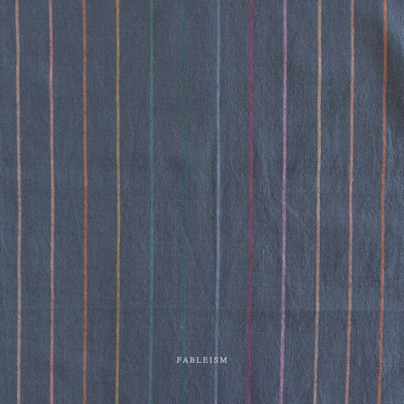 Textured dark fabric with multicolored vertical stripes and 'Fableism' branding.