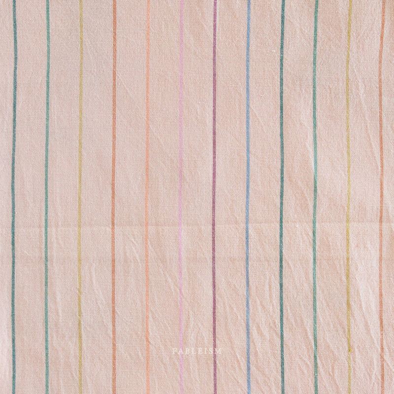 Textured fabric with multicolored vertical stripes on a light pink background