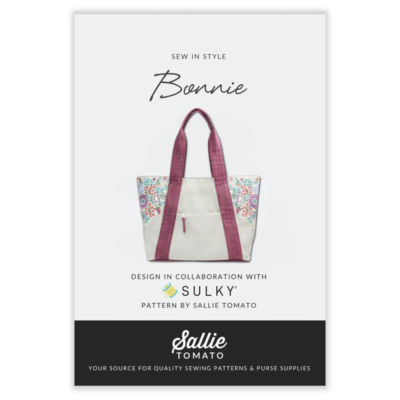 Sewing pattern with picture of white floral tote bag with pink straps on a white background