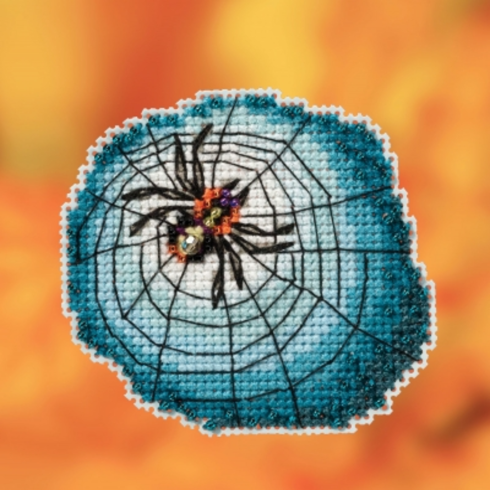 cross stitch spider on web project on orange background