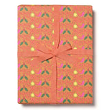 Wrapping paper with the word Merry in red and holly leaves