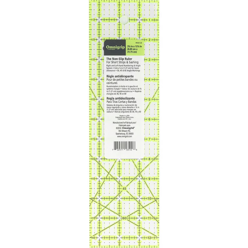 A clear ruler with a neon green grid is displayed against a white background. Their is a white label with text that reads "Omnigrip" along with "3.5 in x 12.5 in" (8.89 cm x 31.75 cm). Lower text reads "The Non-Slip Ruler for Short Strips and Sashing". 